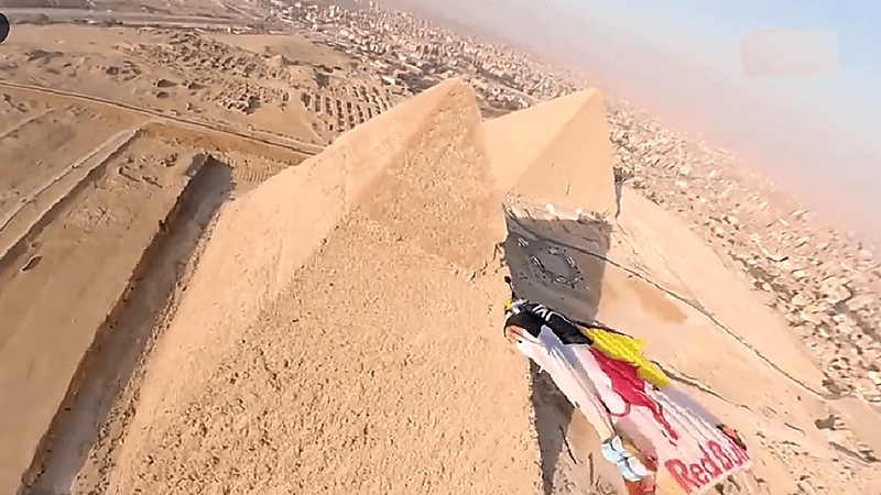 شاهد.. مغامر يطير فوق الأهرامات ويلامس "خفرع"