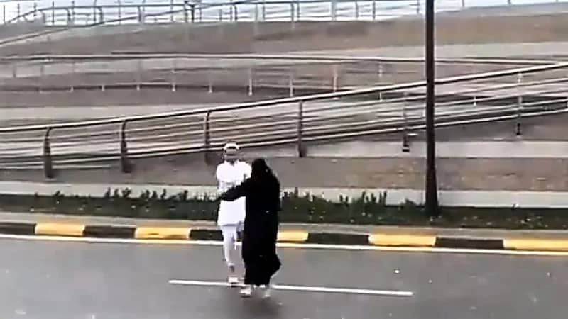 زوجان يوثقان لحظة رومانسية تحت المطر .. فيديو