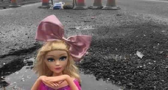 بالصور.. رجل يغرق الطرق بدمي باربي للمطالبة بصيانتها