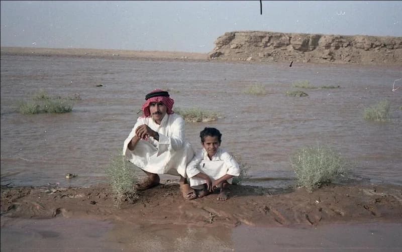 طفل وأبيه وسط جريان وادي الرمة بالقصيم قبل 40 عام