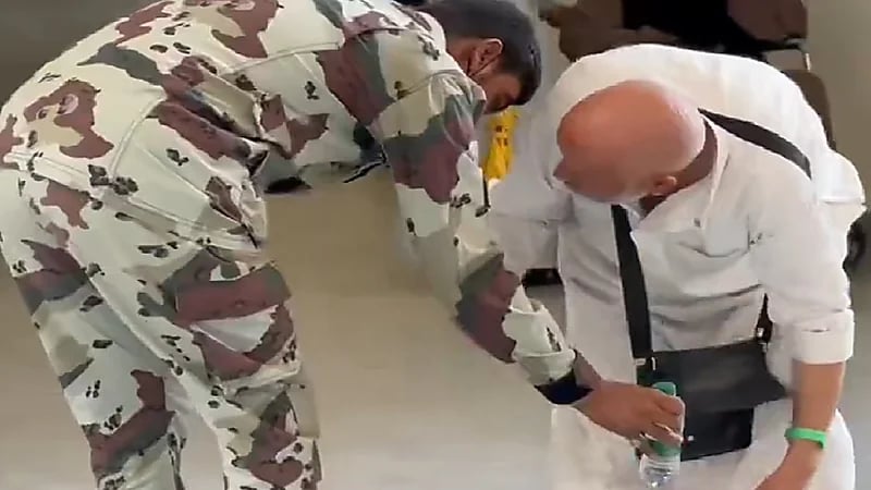 رجل أمن يساعد حاج مسن على النهوض ويلبسه قبعته .. فيديو