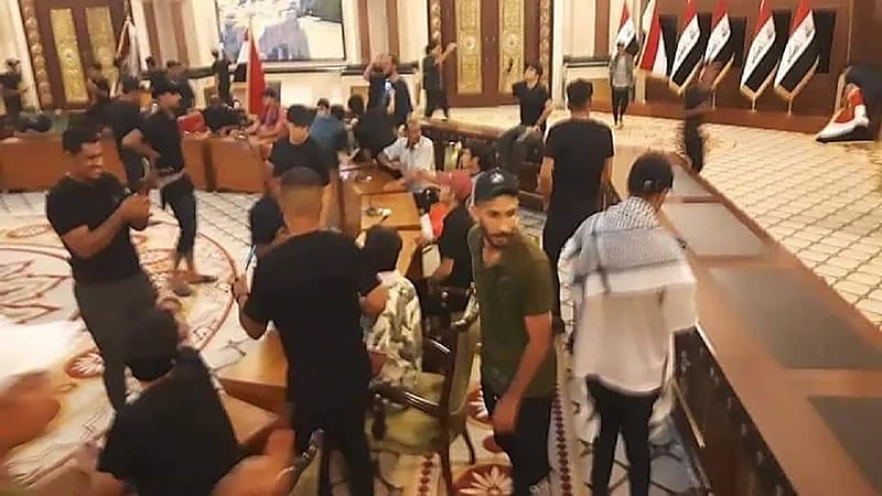 شاهد.. متظاهرون يقتحمون غرفة نوم الرئيس العراقي ويستولون على بدلته