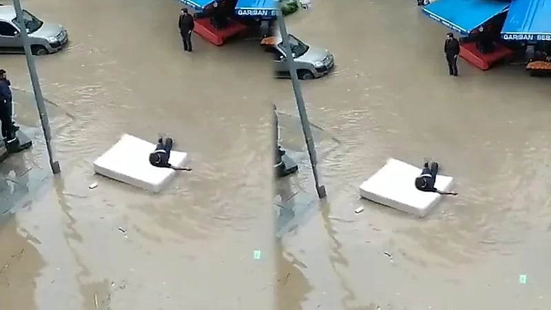 مشهد طريف لتركي استخدم فراشا كـ طوف عائم في مياه الفيضانات..فيديو